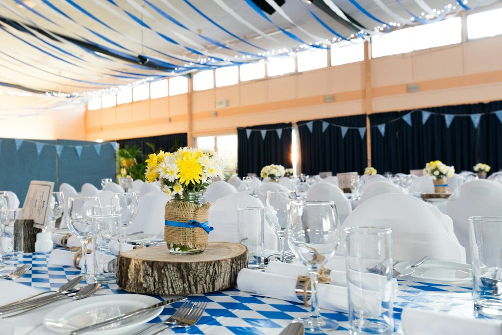 Indian event setup with decorated tables, blue and white drapery — a busy event planner's working scene