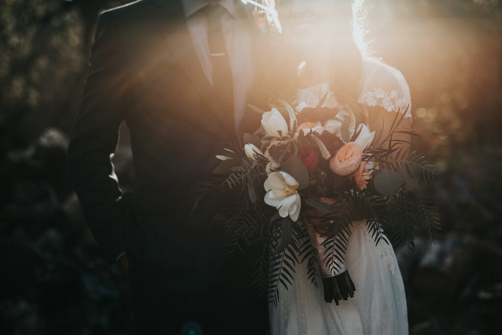 Wedding couple holding a bouquet, photographed in golden-hour light — symbolising business growth and emotional reward